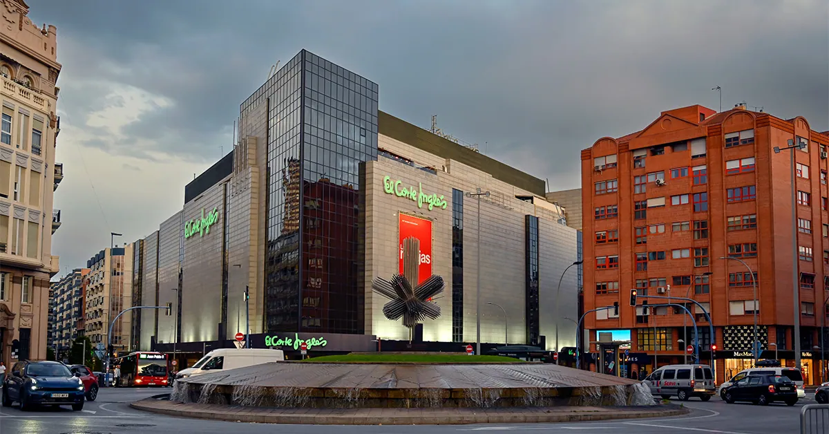 A large shopping centre building with a fountain in front of it
