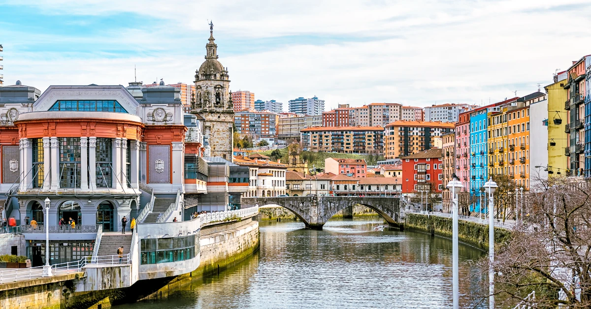 river with a bridge and buildings in the background in Bilbao