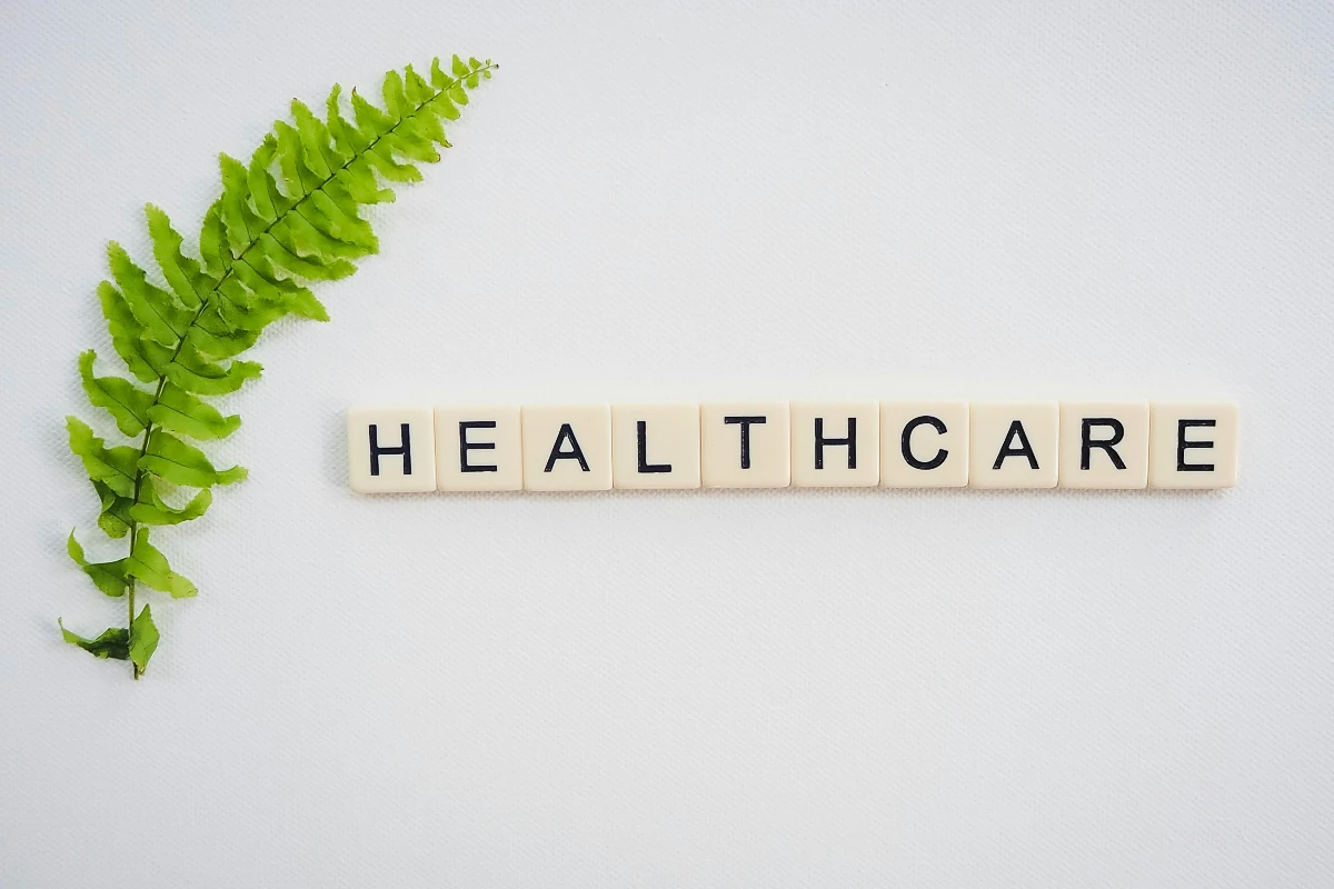 a green leaf next to a white tile word