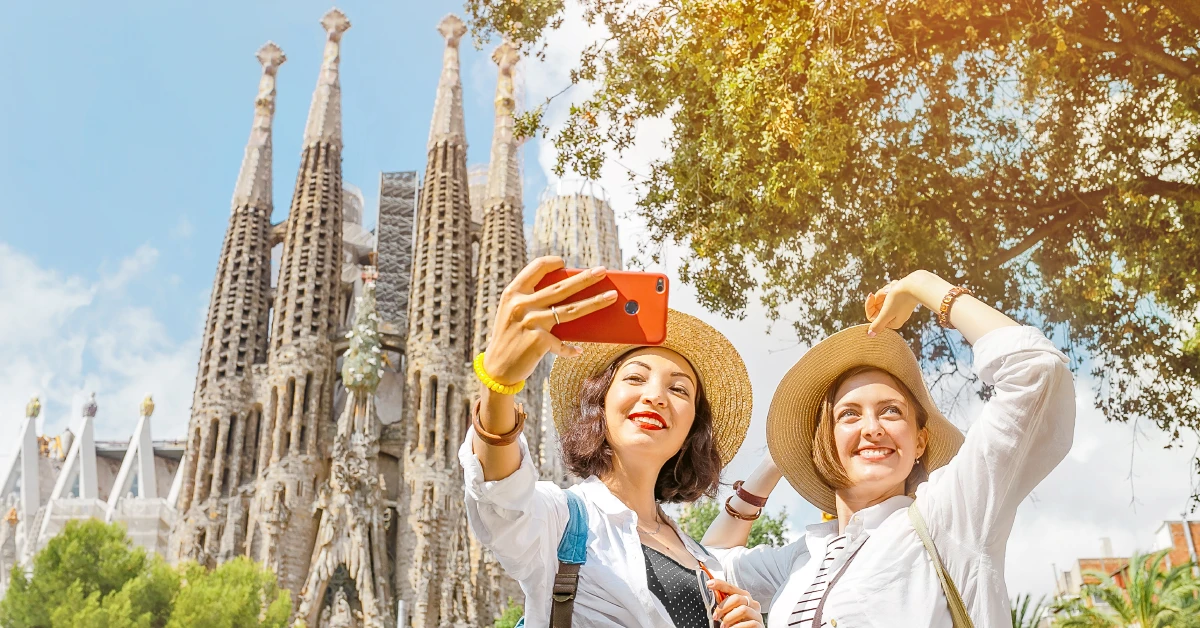group of women taking a selfie in front of a castle with Sagrada Família