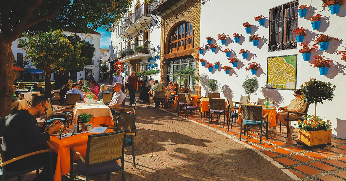 A group of people sitting at tables outside the building